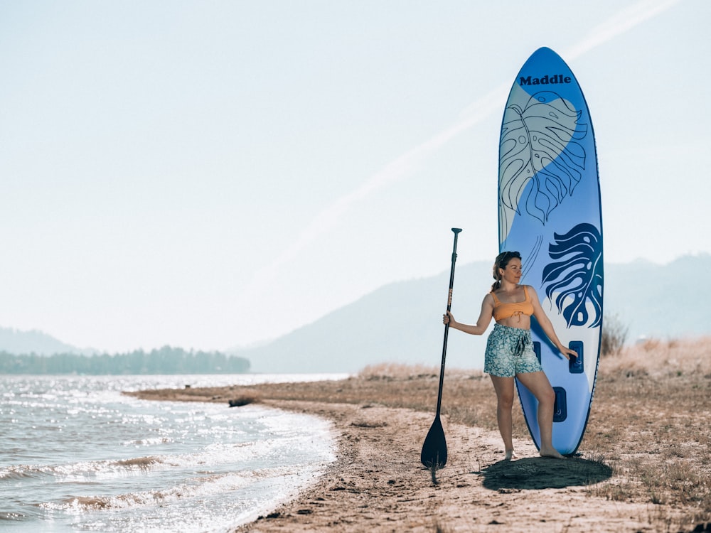 a man holding a surfboard on a beach