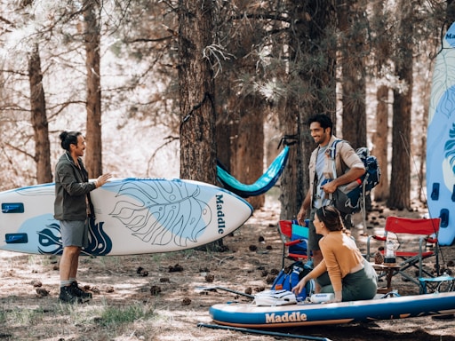 a group of people stand around a surfboard