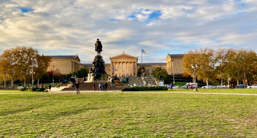 a large building with a statue in the middle of a grass field