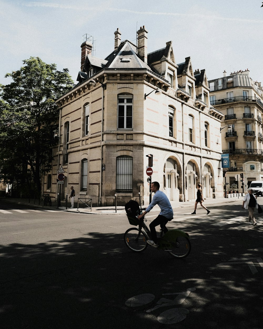 a person riding a bicycle on a street in front of a building