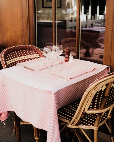 A classic Parisian restaurant table set with a white tablecloth and chairs
