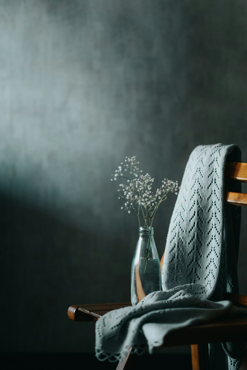 a vase with flowers on a chair