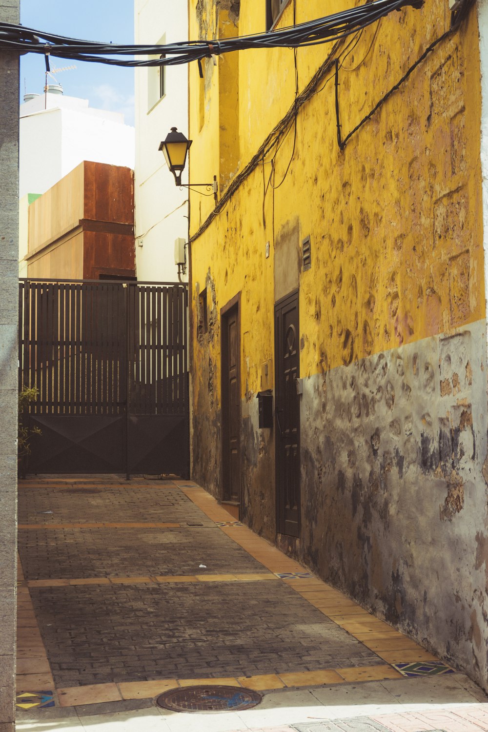 a yellow building with a black gate