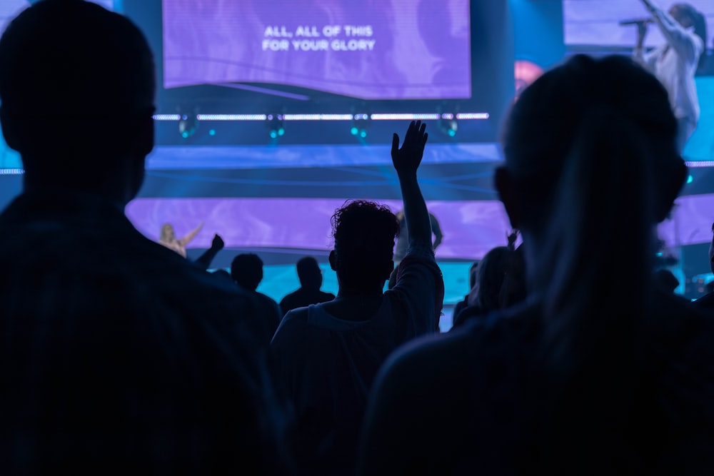 people sitting in a room with a large screen and a large screen