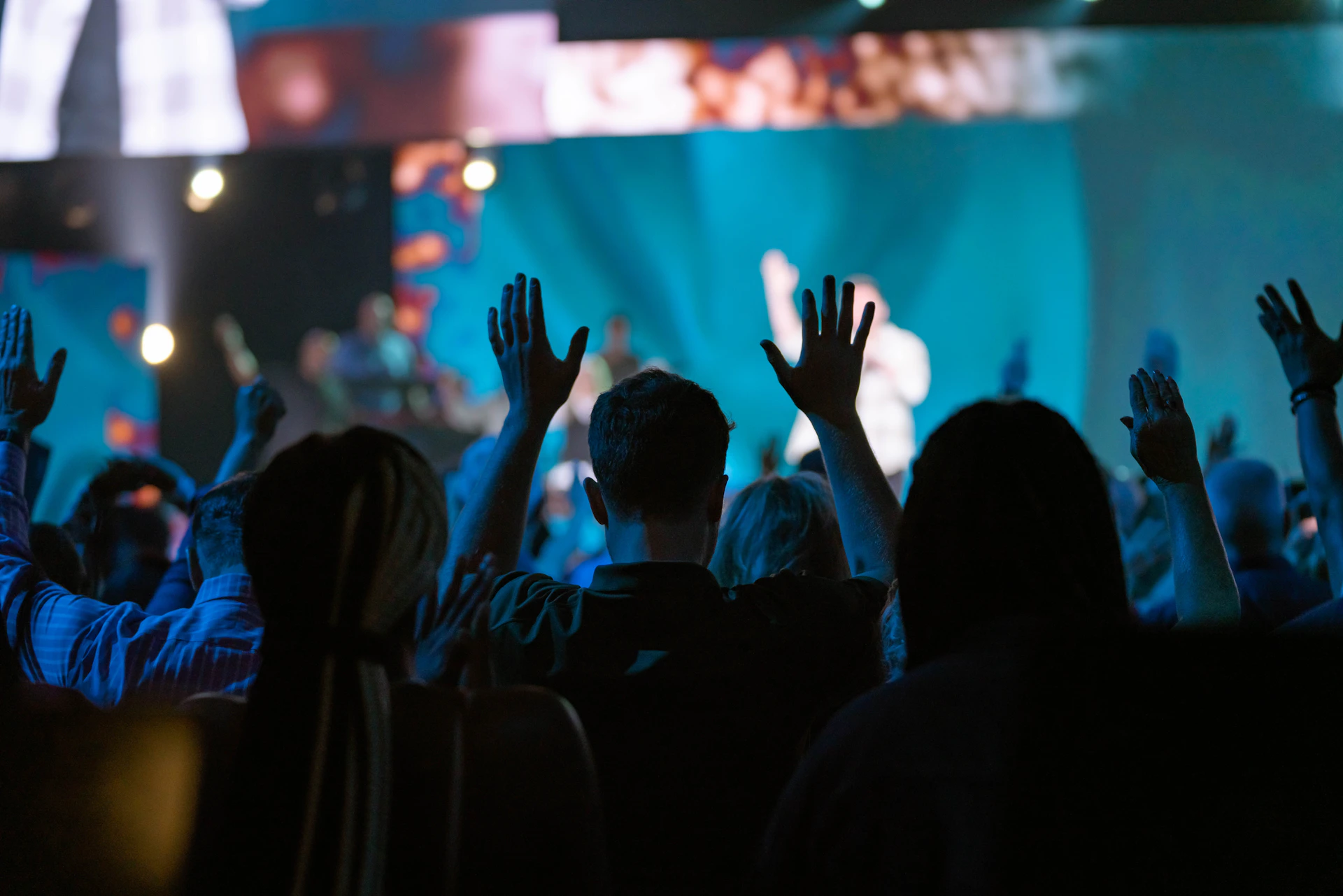 a crowd of people with their hands up in the air