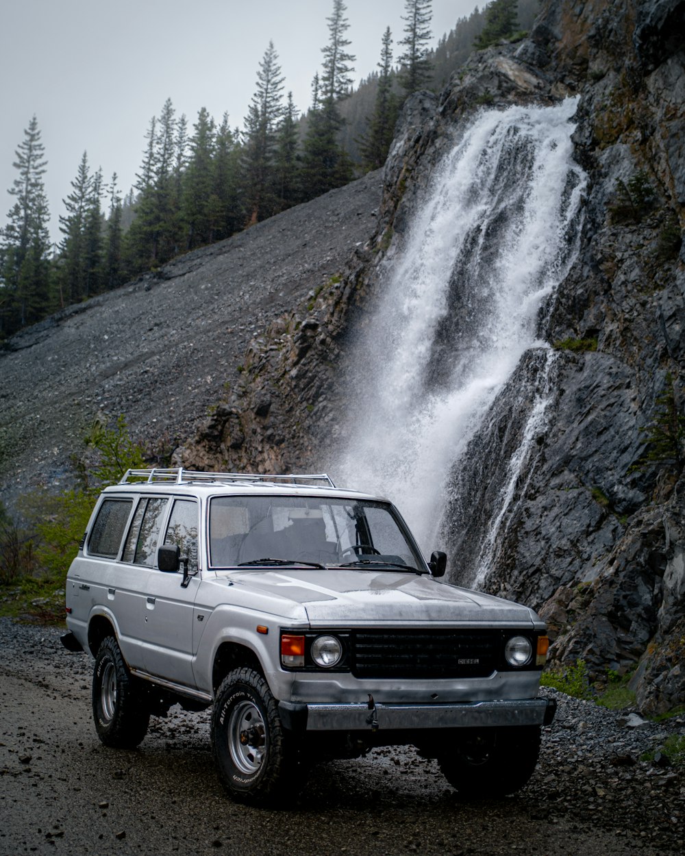 a car parked in front of a waterfall