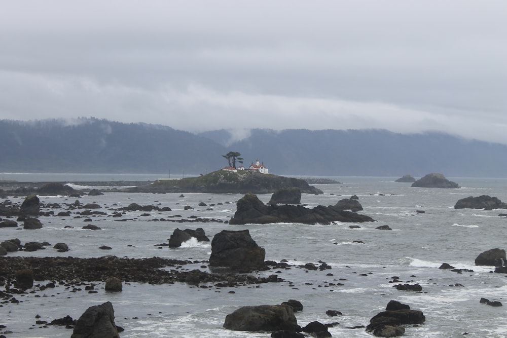 a rocky beach with a structure in the distance