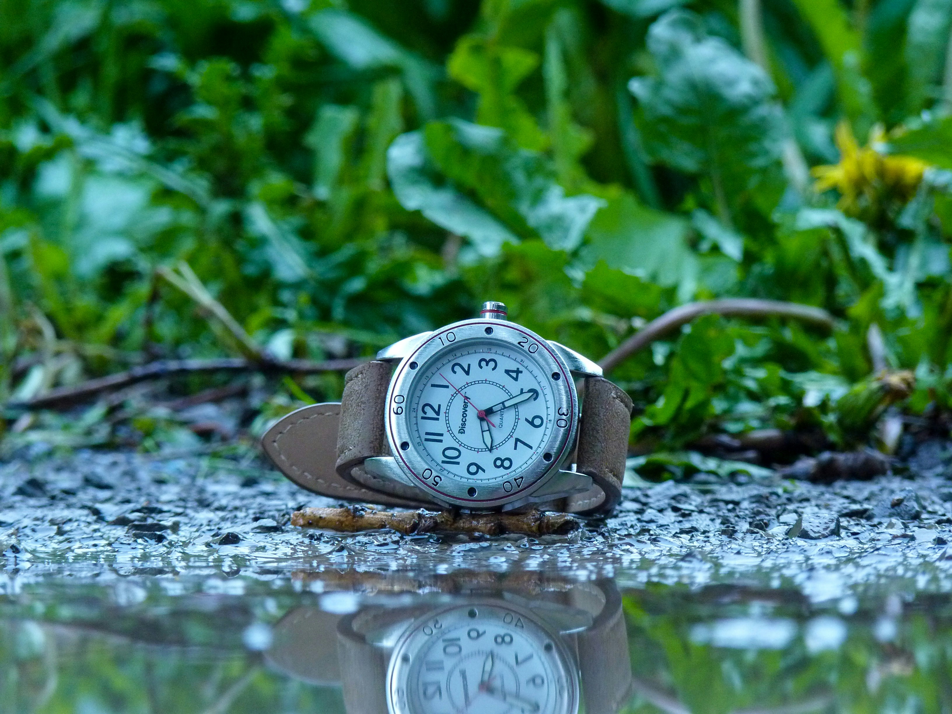 A sturdy wristwatch resting on a rock outdoors