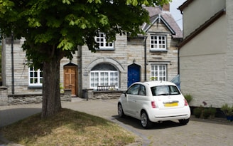 a white car parked in front of a house