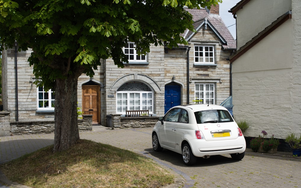 a white car parked in front of a house