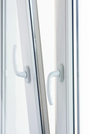 Close-up of a modern UPVC window frame with sleek handles in bright natural light.