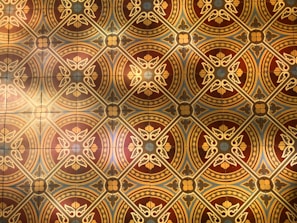 A decorative wall tableau featuring geometric Moroccan motifs in soft, warm tones.