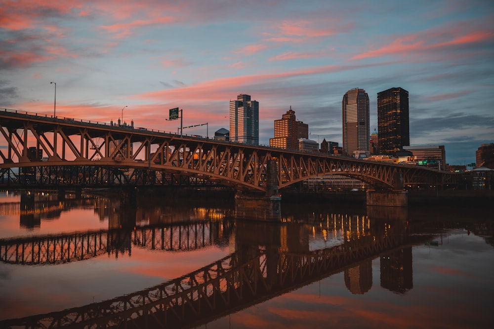 a bridge over water with a city in the background