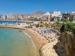 a beach with people and buildings by it