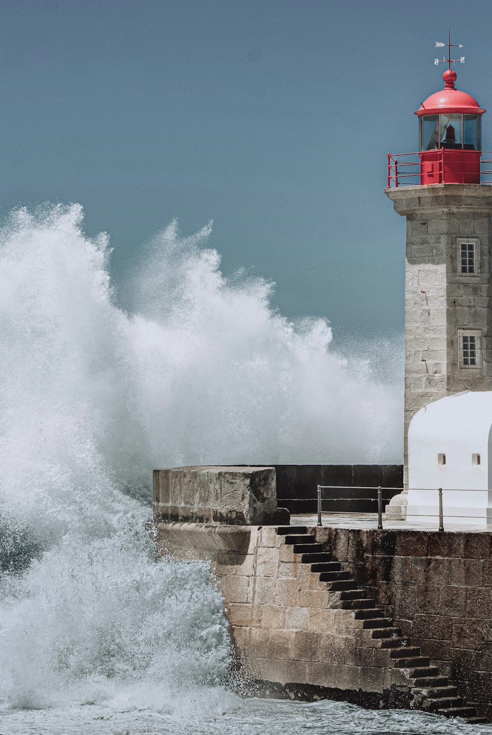 a lighthouse with a wave crashing against it