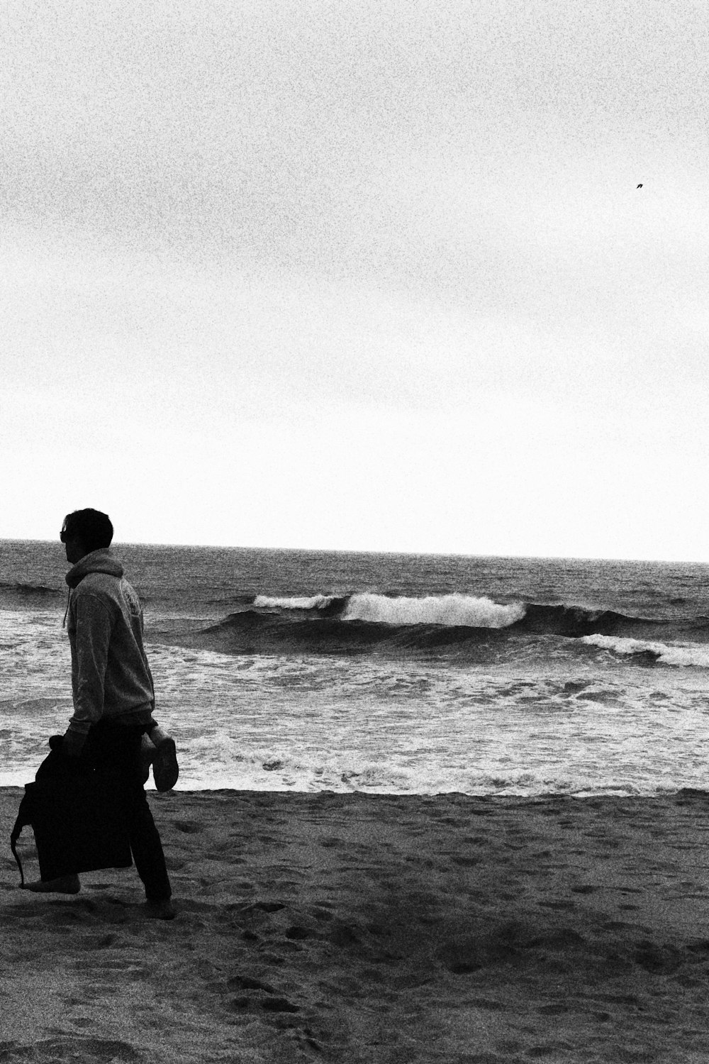 Un hombre cargando una bolsa en una playa