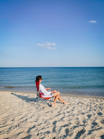 a person sitting on a chair on a beach