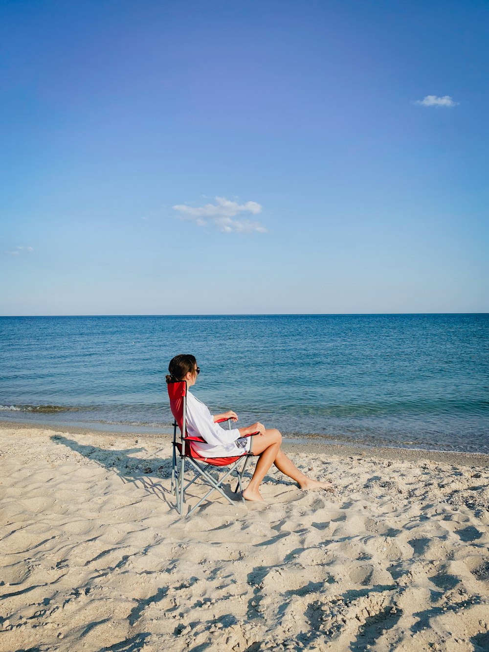 a person sitting on a chair on a beach