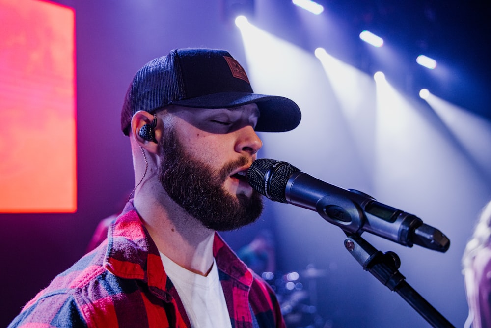 a man with a beard and a hat with a microphone