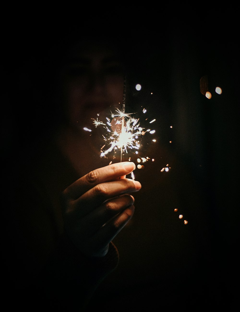 a hand holding a sparkler