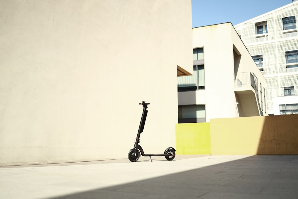 un petit scooter à roues garé à l’extérieur d’un immeuble