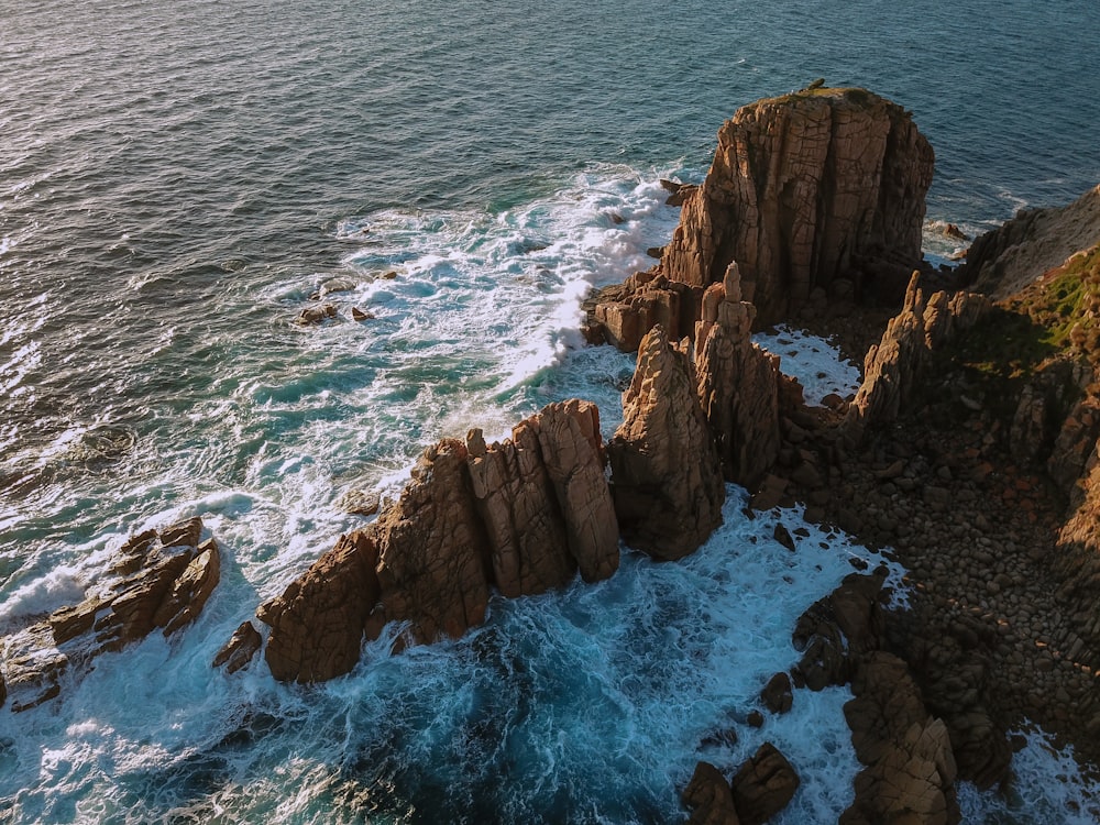 a rocky shoreline with waves crashing against it