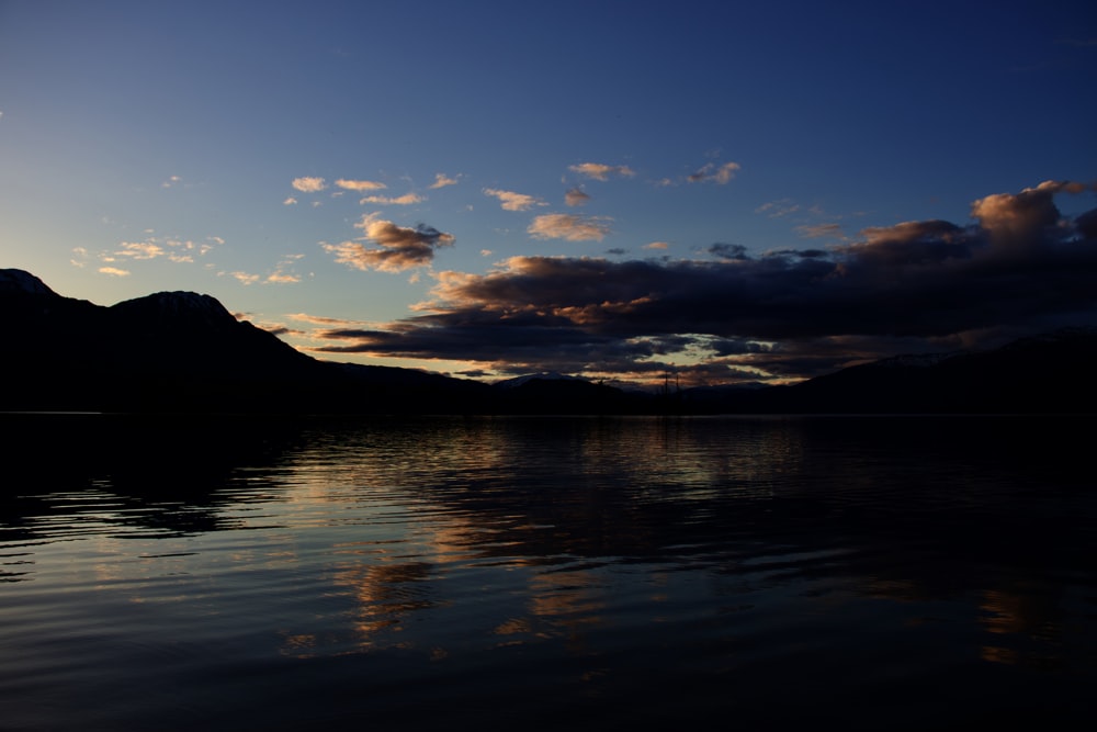 a body of water with mountains in the background