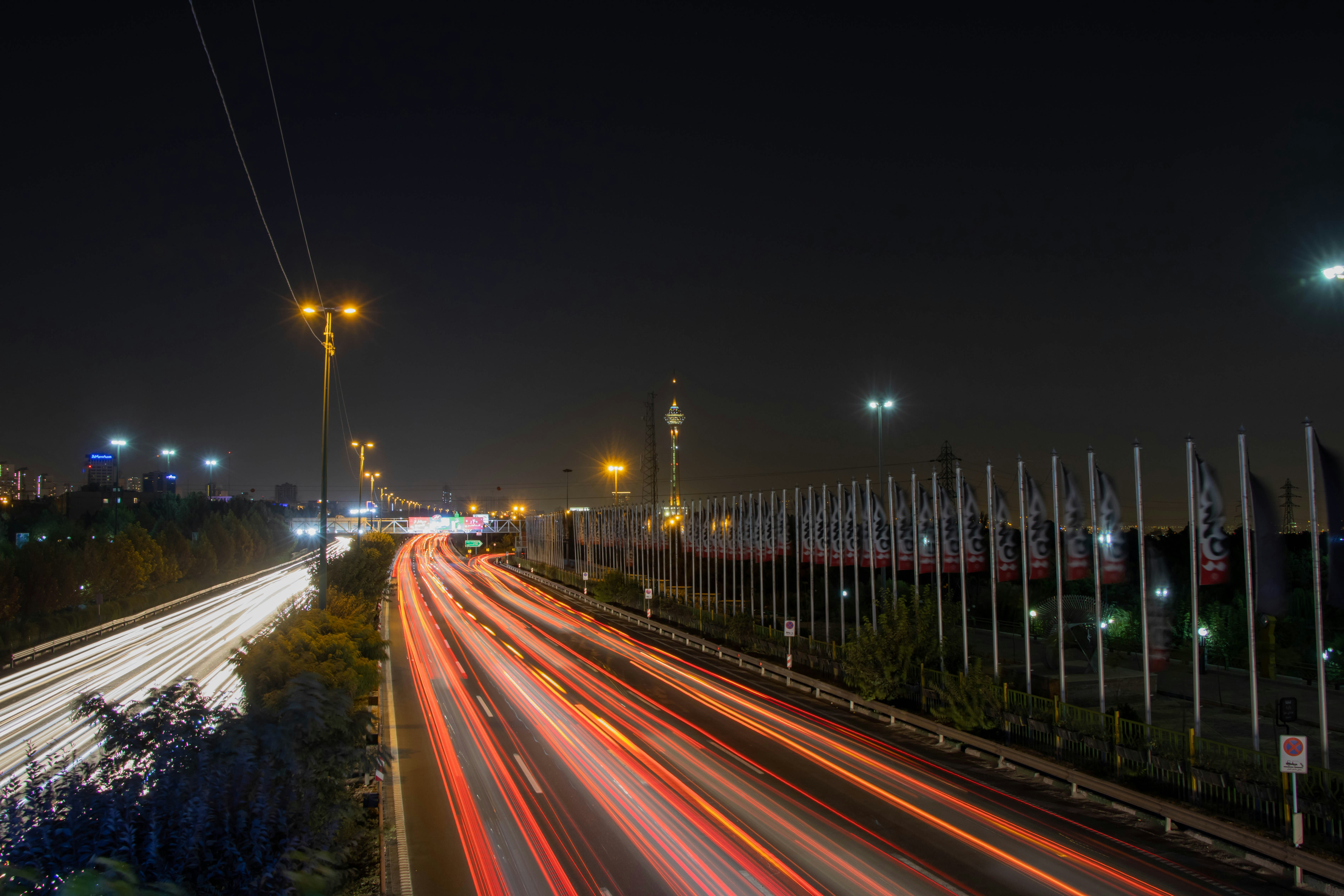 a road with a fence and a row of flags on it