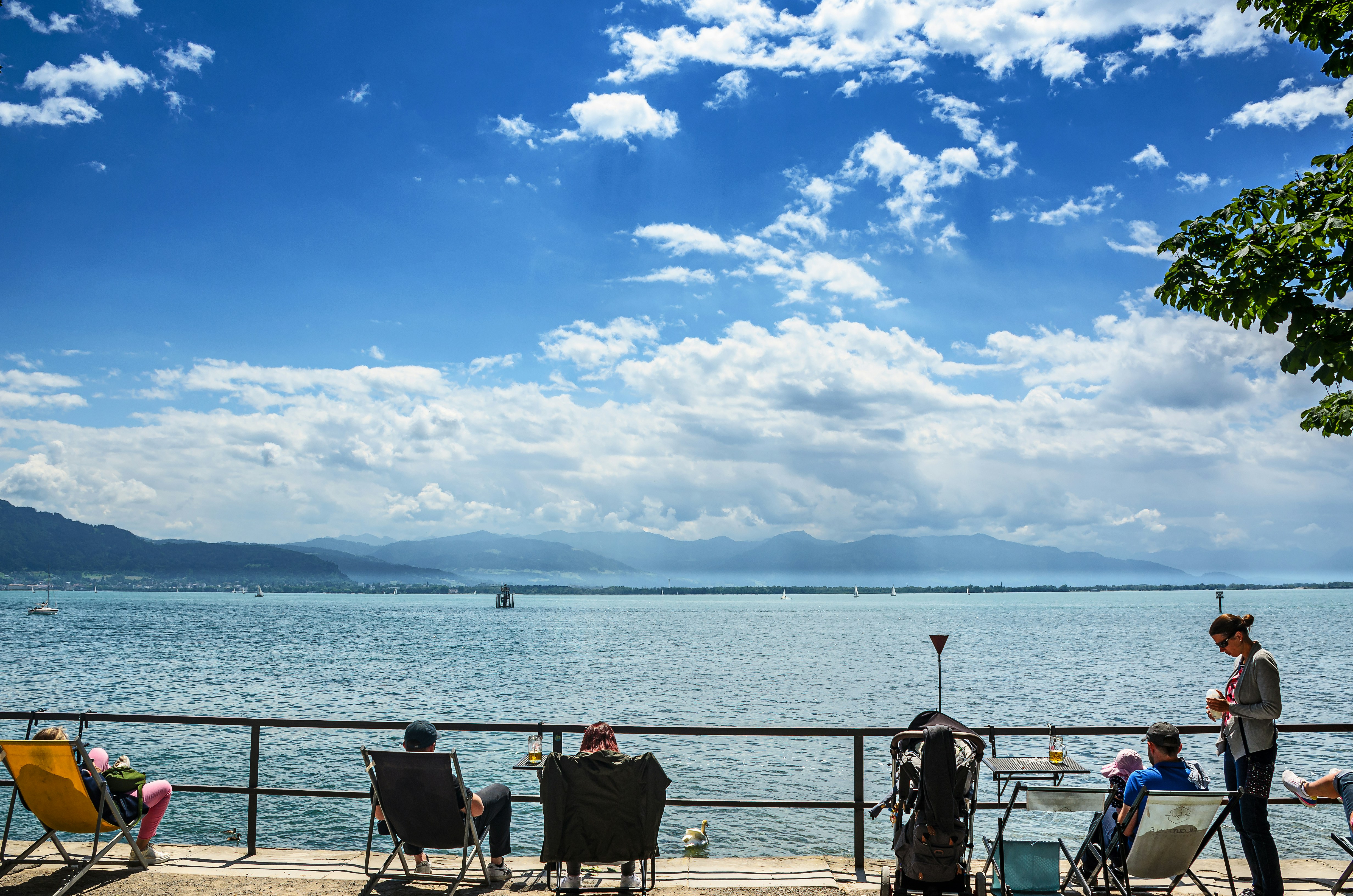 people sitting on a deck overlooking a body of water