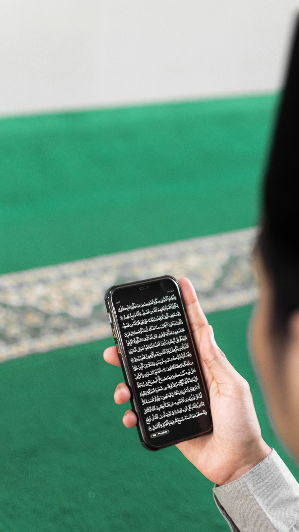 هاتف يعرض محتوى قرآني داخل مسجد