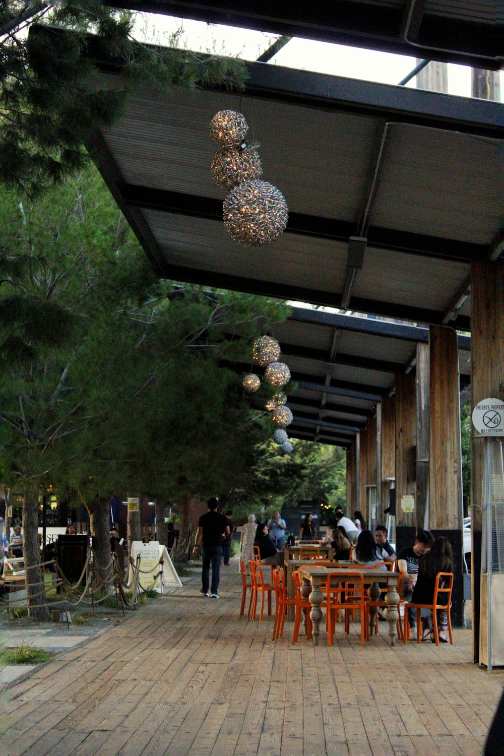 a group of people sitting at tables under a covered area