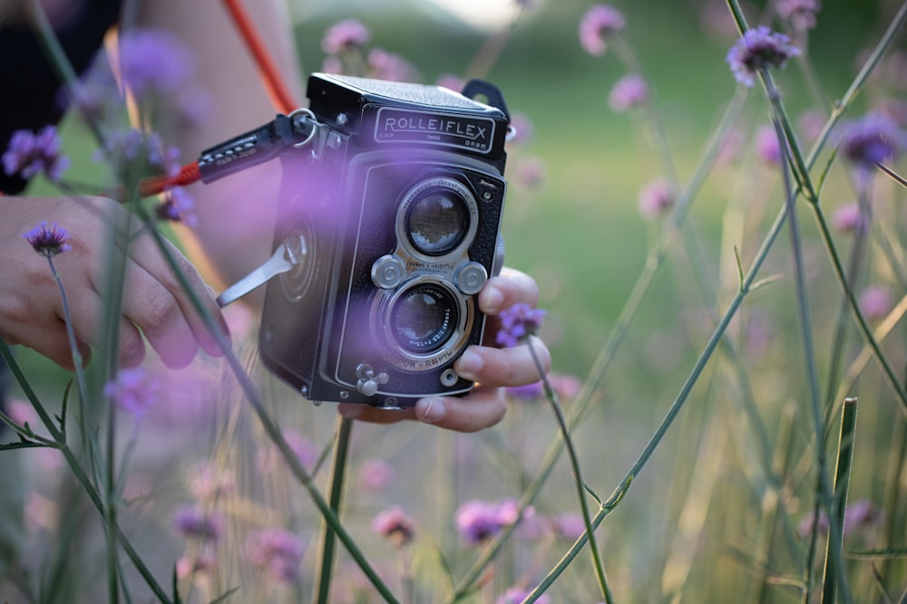 una persona che tiene in mano una macchina fotografica