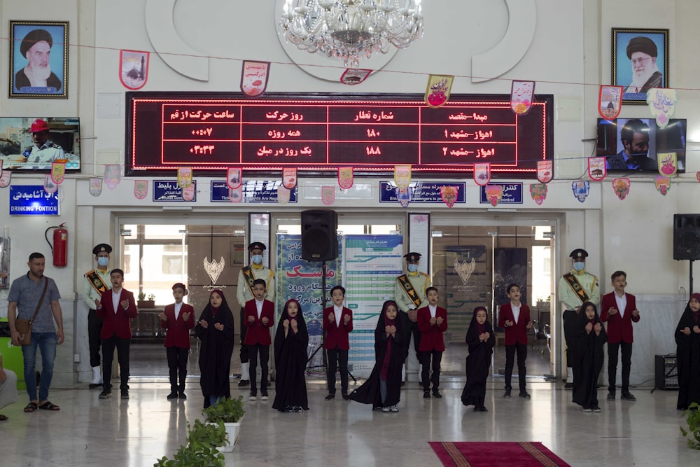 a group of people standing in front of a building with a sign