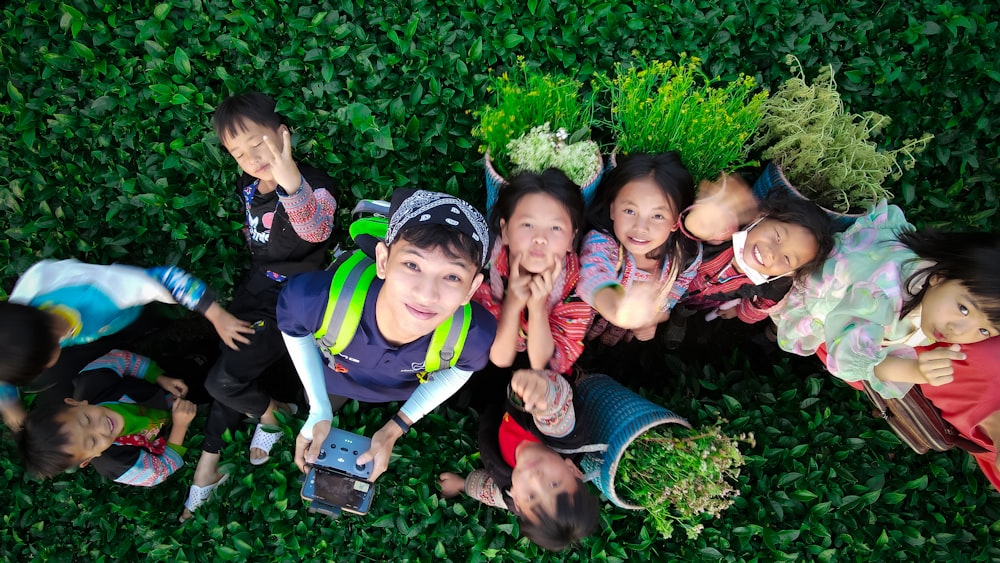 a group of children sitting in the grass