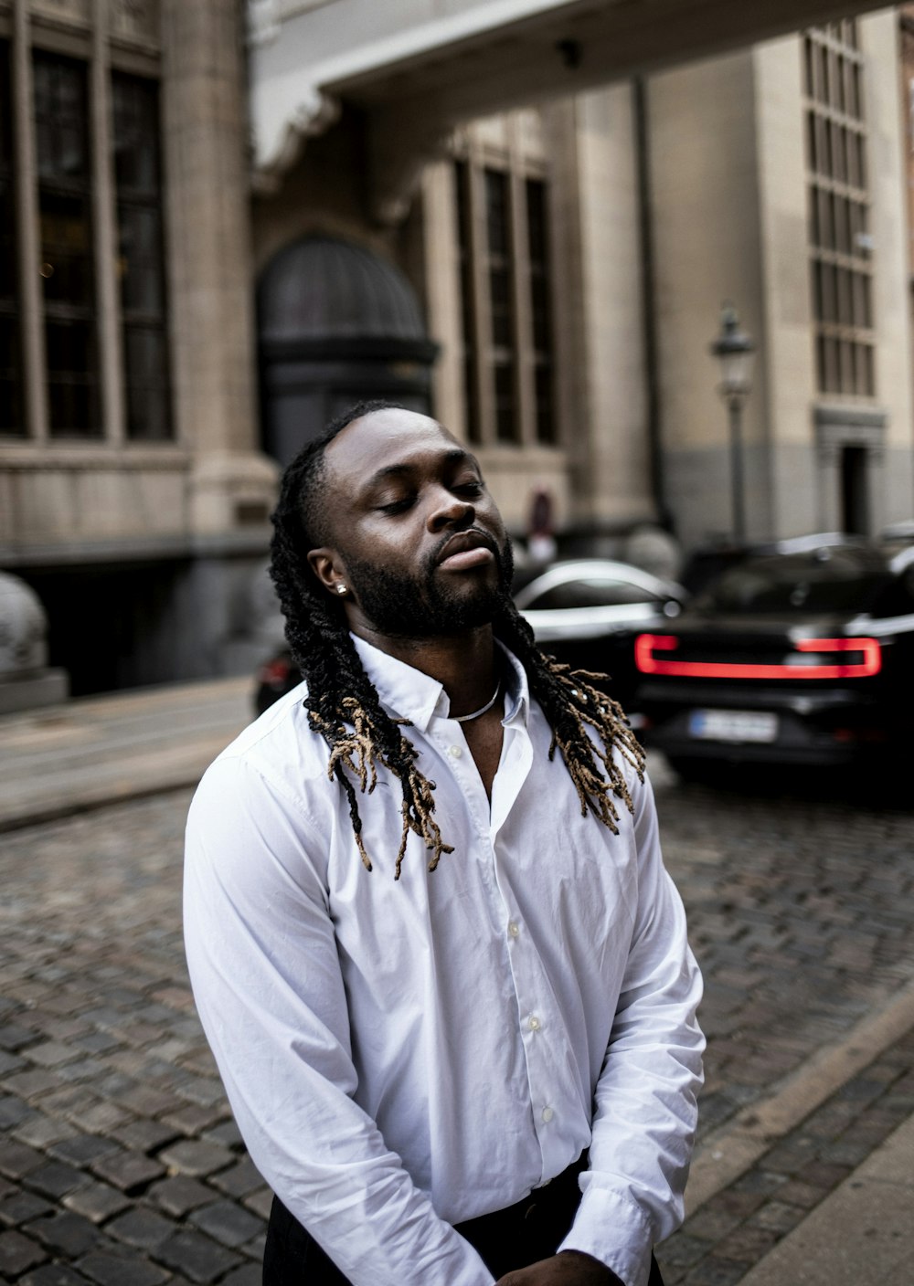 a person with a beard and a white shirt on a street