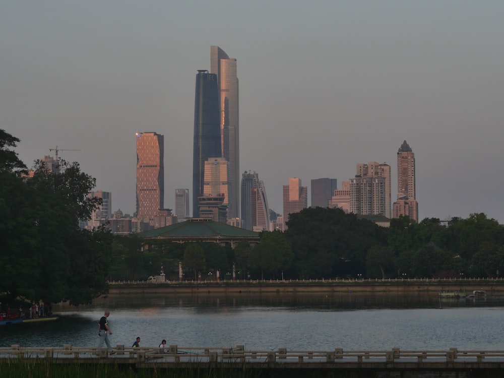 a city skyline with a body of water in front of it