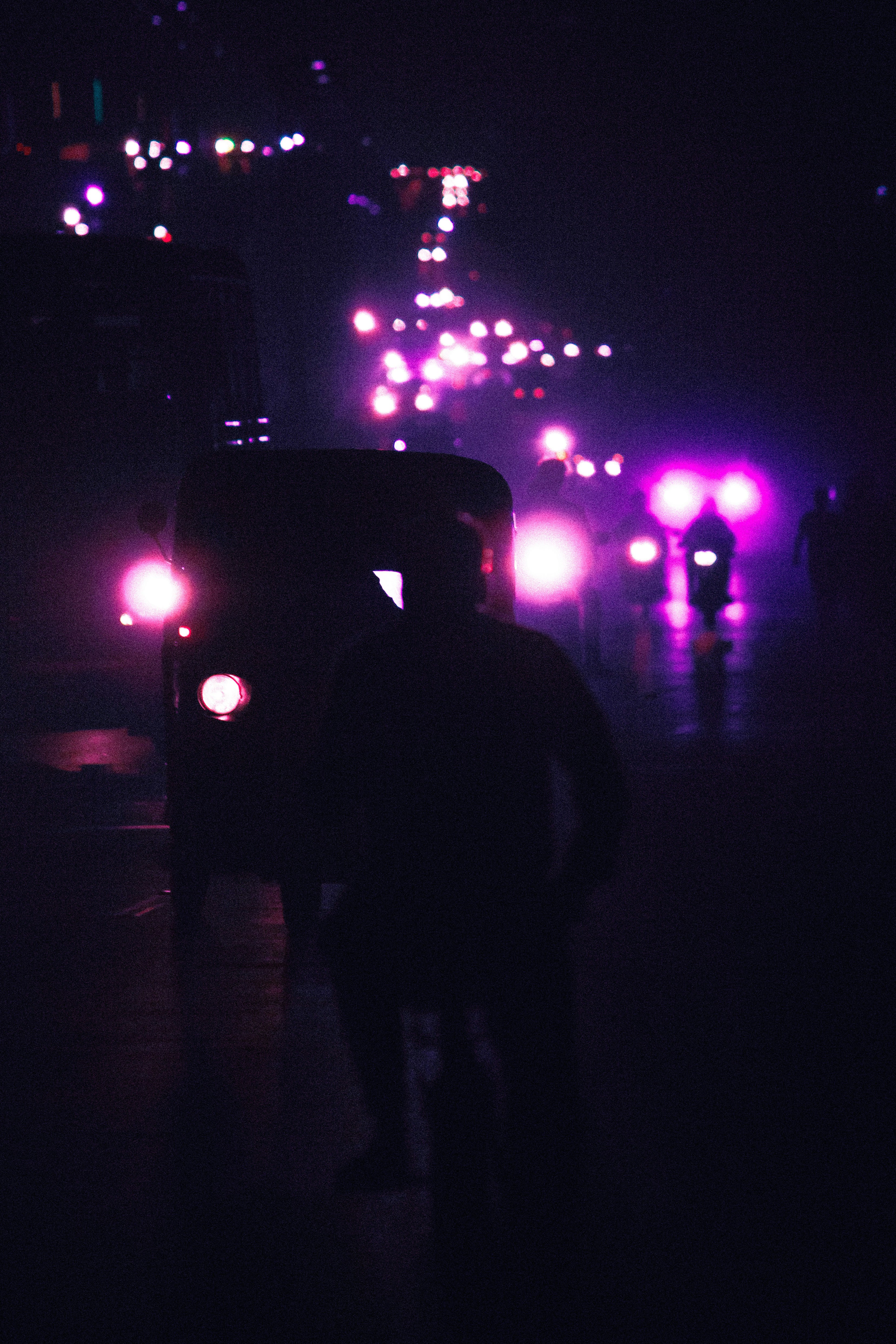 a person standing in front of a car with lights on it