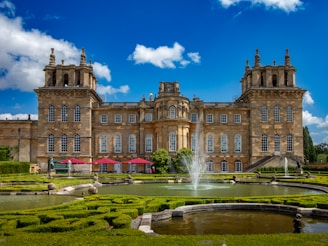 a large building with a fountain in front of it with Blenheim Palace in the background