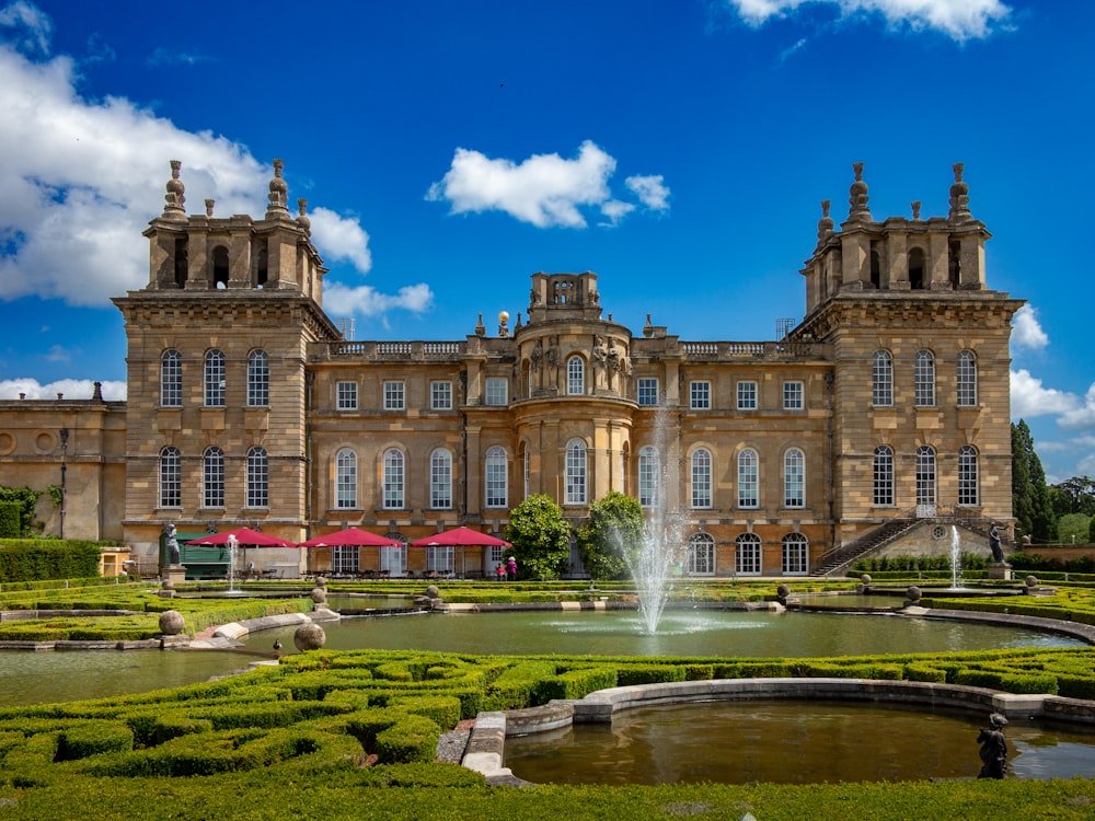 a large building with a fountain in front of it with Blenheim Palace in the background