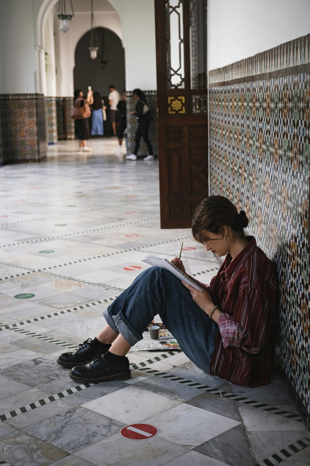 a person sitting on the ground reading a book