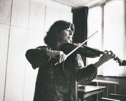 An adult violinist practicing in a cozy home studio, surrounded by music sheets.