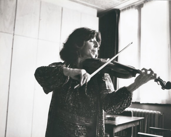 A violinist practicing in a modern music studio with natural light.