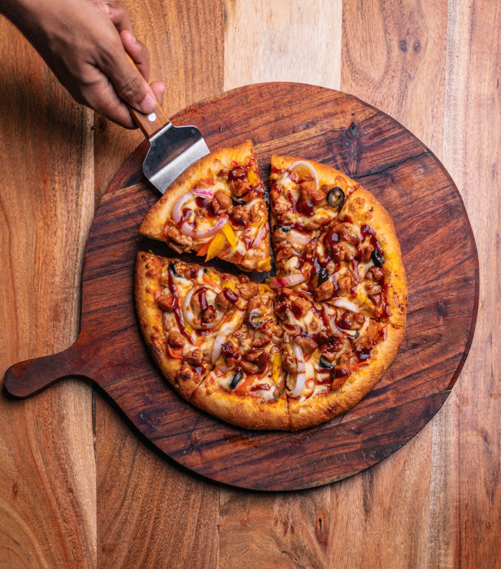 a person cutting a pizza