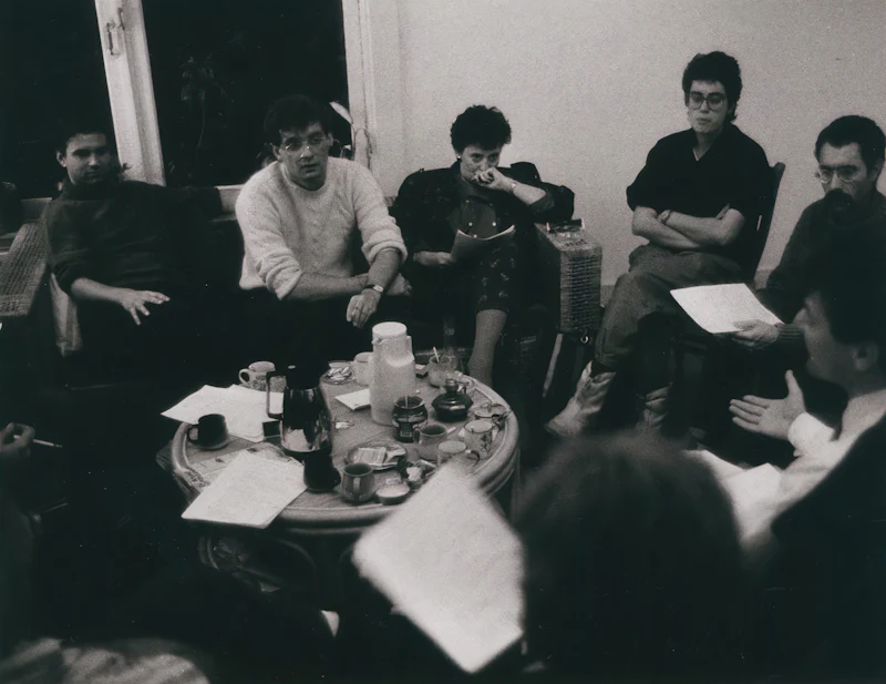 A group of people sitting together around a table for a reading gathering