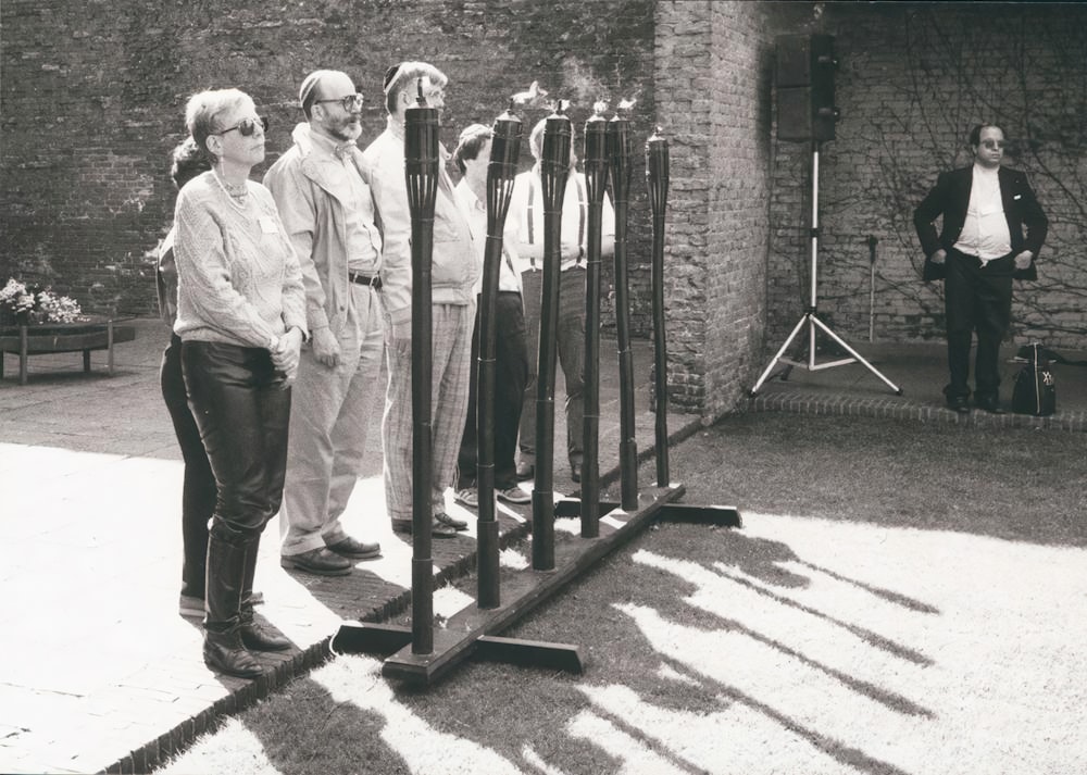 a group of people standing next to a fence