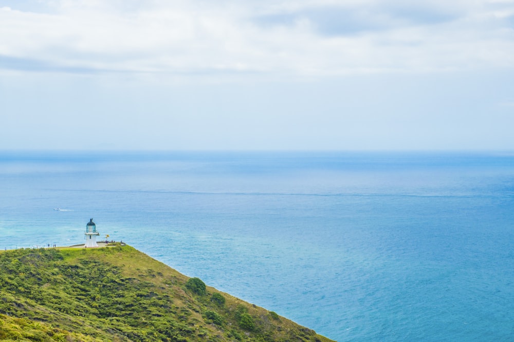 a lighthouse on a hill overlooking the ocean