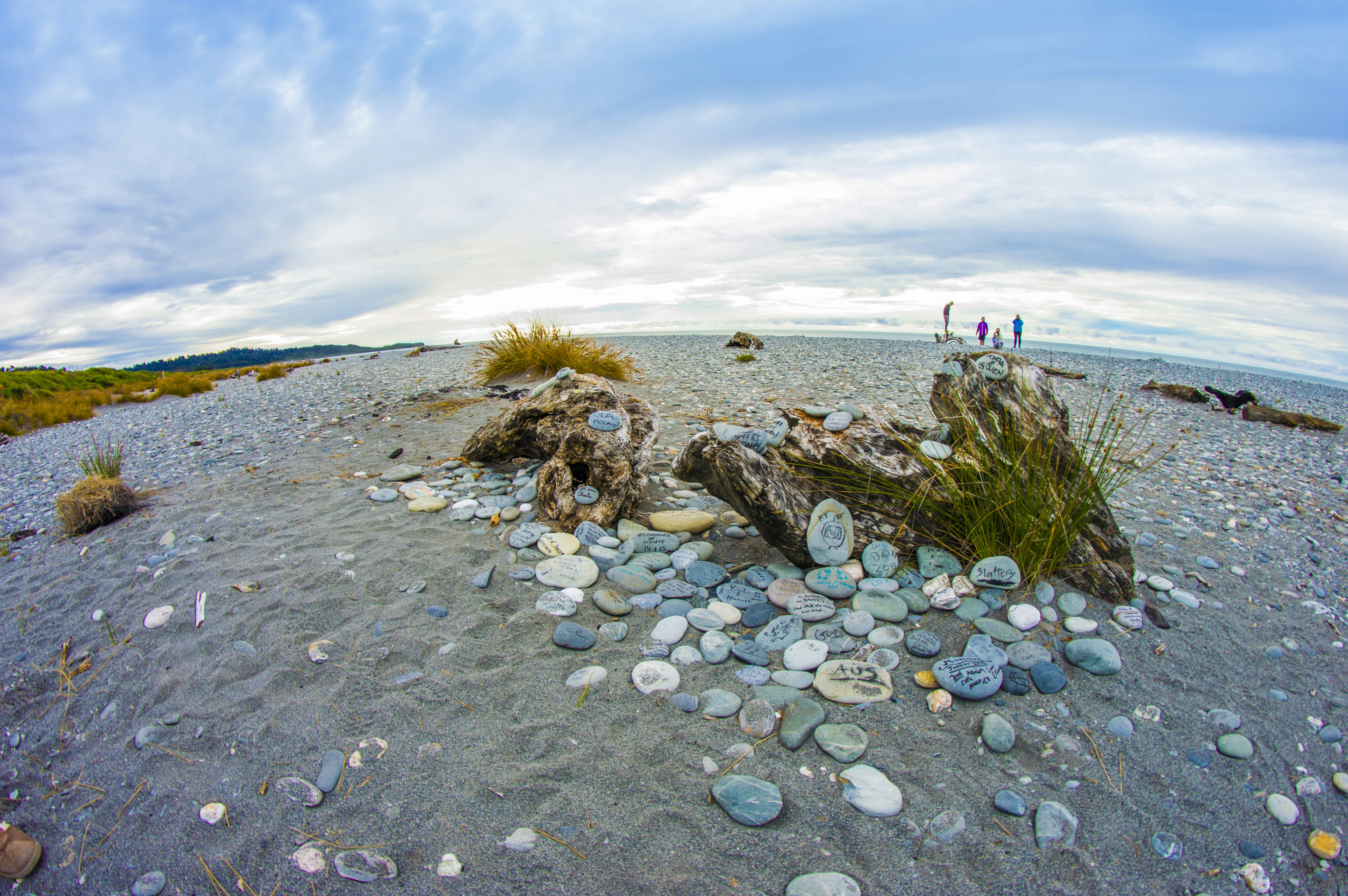 a rocky beach with people walking on it