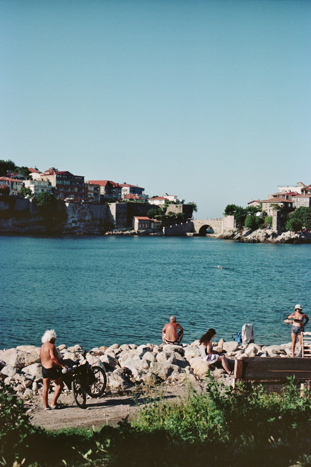 a group of people standing next to a body of water