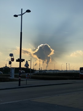 Industrial tanks and chimneys emitting steam at sunset