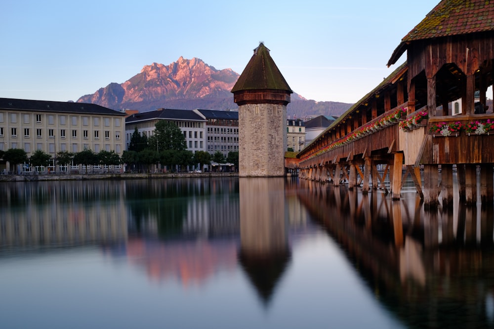 a body of water with buildings and mountains in the background